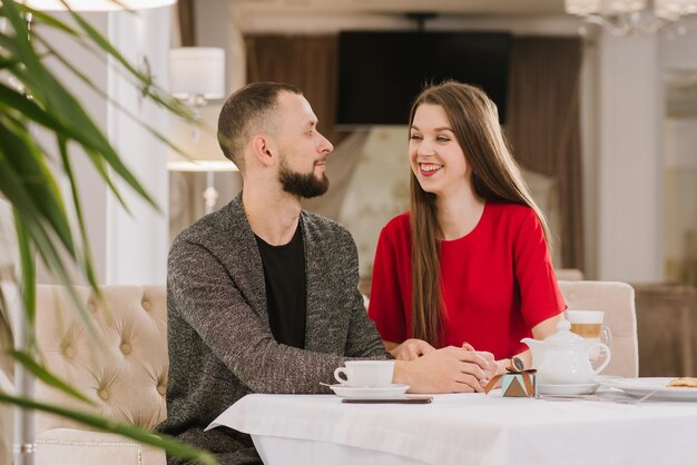 Giovani e coppie felici che parlano e si divertono al ristorante