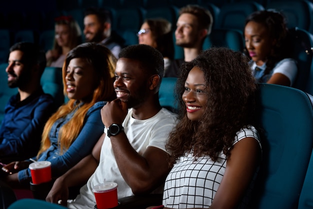 Giovani felici che sorridono con gioia mentre guardano un film insieme al cinema locale