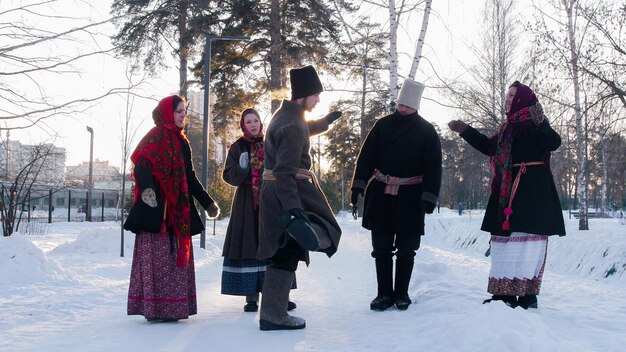 Giovani folk russi con stivali di feltro che ballano all'aperto durante l'inverno