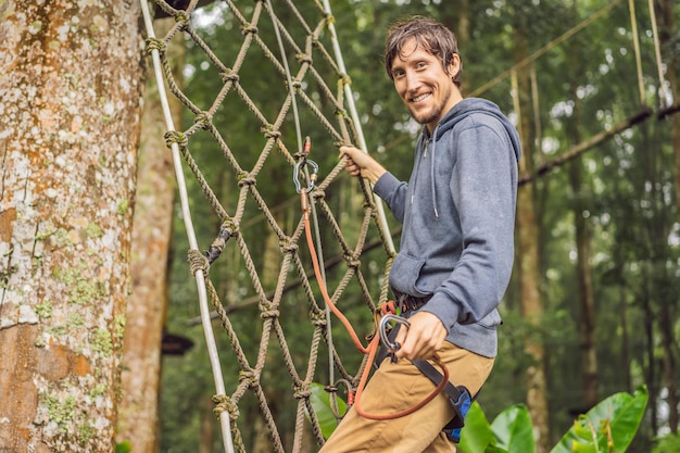 Giovani forti in un parco di corde sullo sfondo di legno