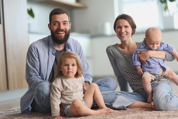 Giovani genitori che giocano con i bambini in cucina