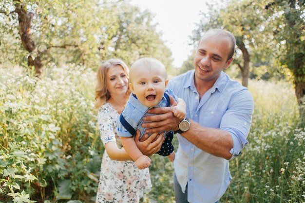 Giovani genitori con figlio piccolo nel parco estivo