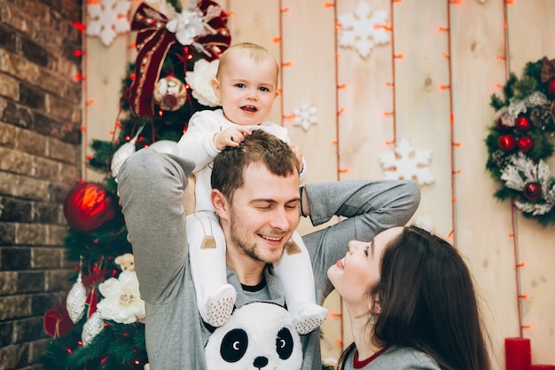 Giovani genitori con il giovane figlio vicino all'albero di Natale