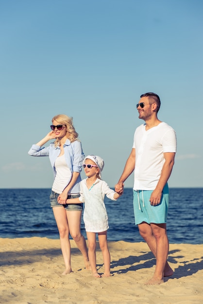 Giovani genitori e la loro piccola figlia carina in occhiali da sole.