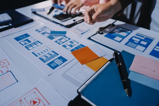 Giovani imprenditori asiatici team creativo lavorano insieme progetto di progettazione di software per applicazioni mobili riunione Brainstorm tecnologia internet smartphone web app designer ufficio coworker concetto di lavoro di squadra