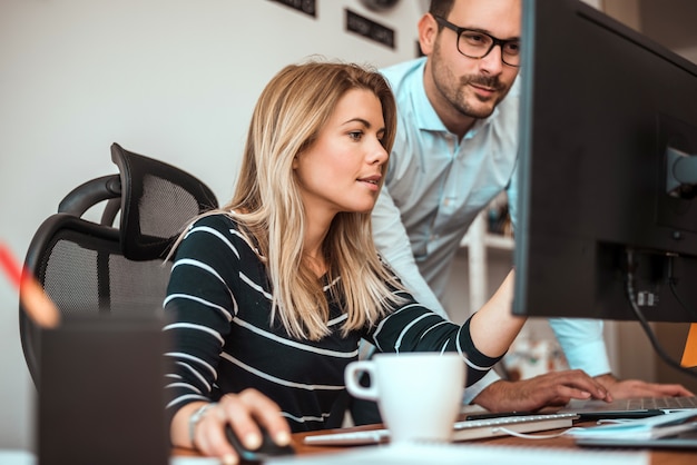 Giovani imprenditori che lavorano insieme in ufficio moderno.