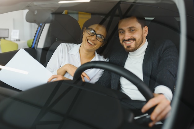 Giovani imprenditori che lavorano insieme mentre viaggiano in auto.