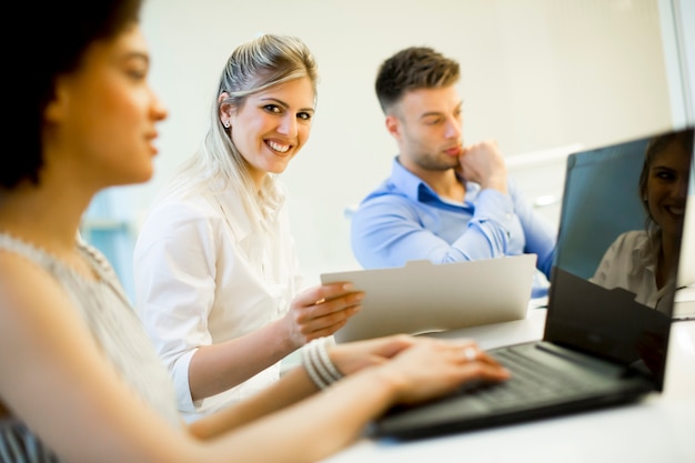 Giovani imprenditori che utilizzano computer portatile e sorridente mentre si lavora in ufficio