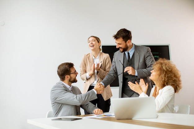 Giovani imprenditori seduti al tavolo della riunione nella sala conferenze discutendo il lavoro e la strategia di pianificazione