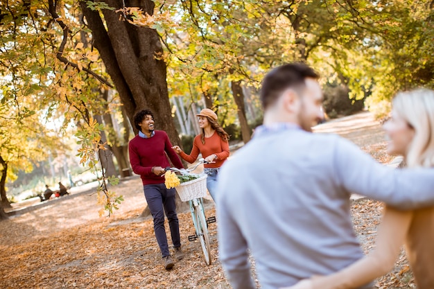 Giovani multirazziali che camminano nel parco in autunno e divertirsi