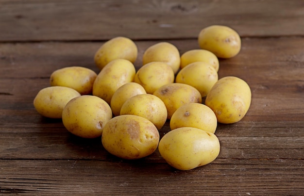 Giovani piccole patate su una tavola di legno marrone