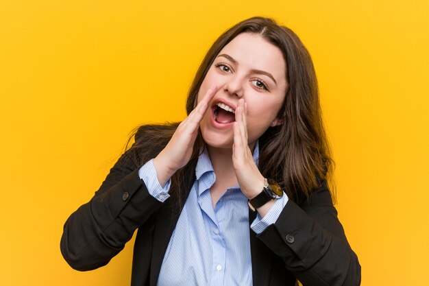 Giovani plus size caucasica donna d'affari gridando eccitati al fronte.