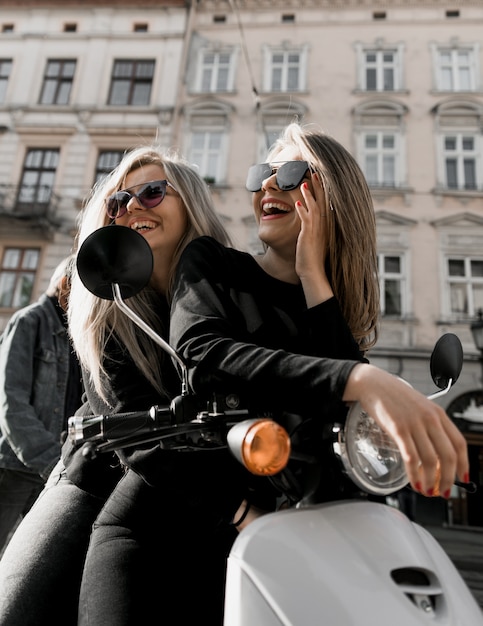 Giovani ragazze allegre con scooter