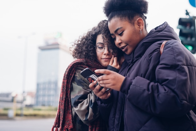 giovani ragazze che utilizzano smartphone in città