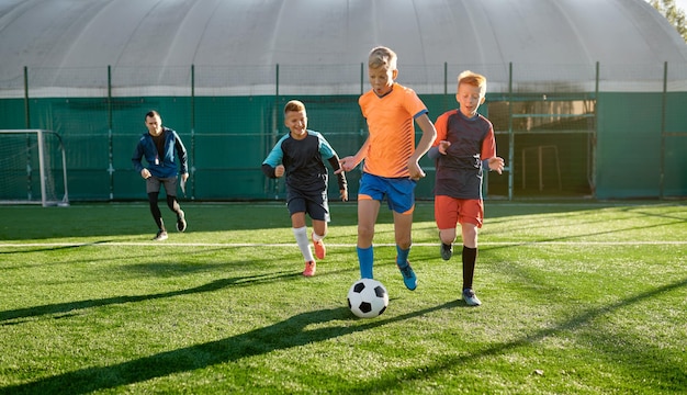 Giovani ragazzi che giocano a calcio durante la competizione junior alla scuola sportiva. Partita finale del torneo di calcio per bambini