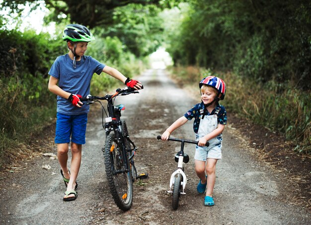 Giovani ragazzi che spingono le loro biciclette