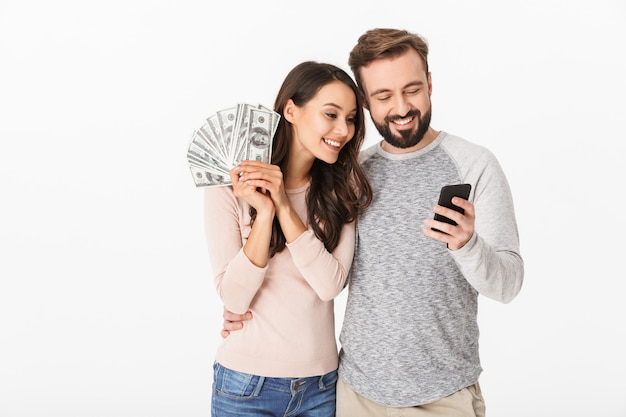 Giovani soldi amorosi felici della tenuta delle coppie facendo uso del telefono cellulare.