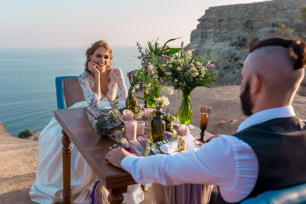 Giovani sposi appena sposati felici che celebrano e si divertono al bellissimo tramonto sulla spiaggia