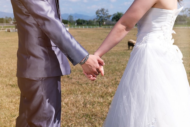 giovani sposi asiatici sposi e sposa in giardino.