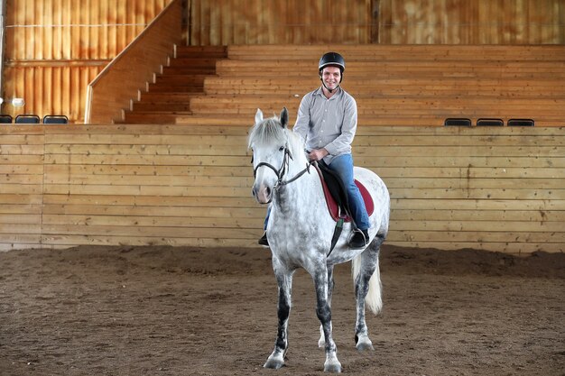 Giovani su un addestramento di cavalli in un'arena di legno