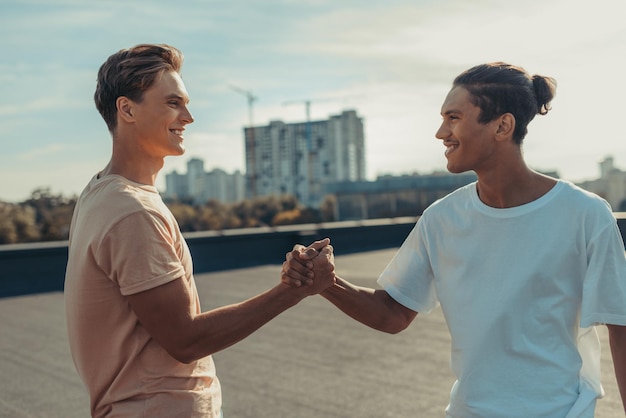 Giovani uomini belli che si stringono la mano