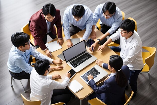 Giovani uomini d'affari asiatici lavorano insieme in una riunione di brainstorming di progetti utilizzando un computer portatile Collega di lavoro ufficio di avvio o persone concetto di lavoro di squadra Visita superiore dimensione del banner con spazio di copia