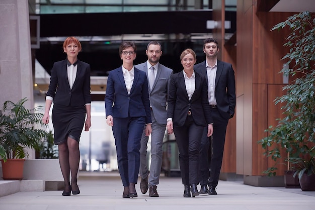 giovani uomini d'affari che camminano in gruppo, un gruppo di persone all'interno della moderna sala dell'ufficio