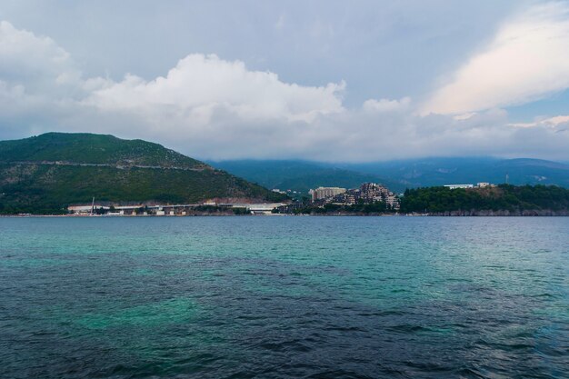 Girato da uno yacht in primo piano del mare e una bella scena di montagne sulla riva in una luminosa giornata di sole