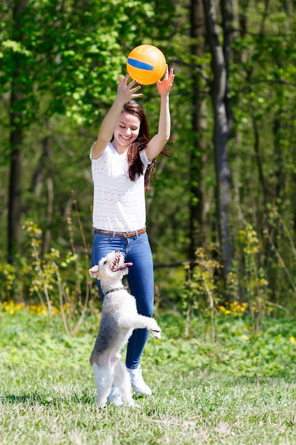 Girl in motion Ball addestra il cane in un parco estivo