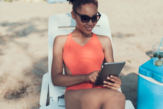 Girl in Sunglasses utilizza Tablet PC. Sunny Daytime.