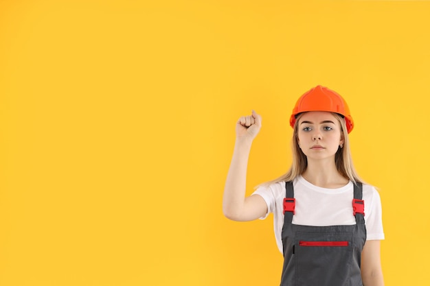 Girl power concept con builder femminile su sfondo giallo
