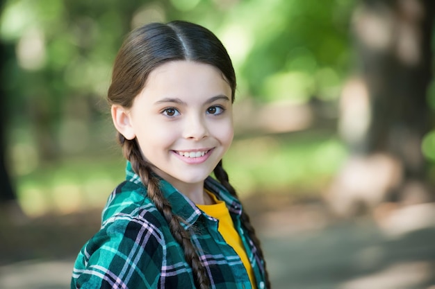 Girl scout trecce carine indossano abiti a scacchi sfondo natura concetto di pensiero positivo