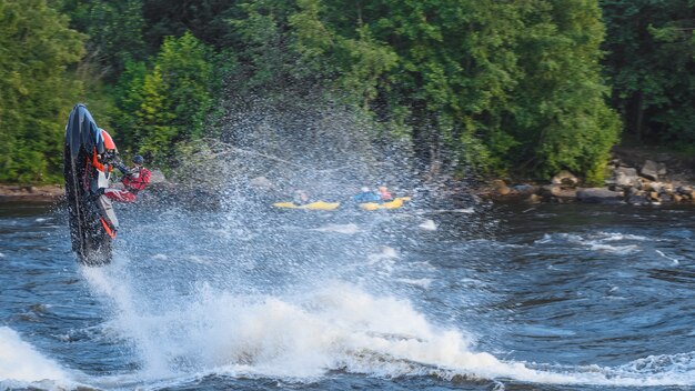 Giro acrobatico su una moto d'acqua su un fiume agitato Luce naturale