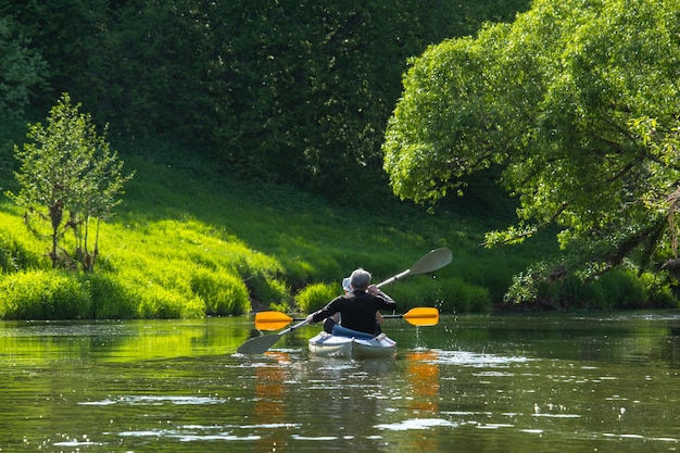 Gita in kayak in famiglia per signore e senora Un'anziana coppia sposata che rema in barca sul fiume un'escursione in acqua un'avventura estiva Sport legati all'età gioventù mentale e turismo della salute vecchiaia attiva