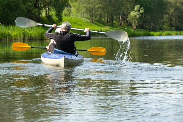 Gita in kayak in famiglia per signore e senora Un'anziana coppia sposata che rema in barca sul fiume un'escursione in acqua un'avventura estiva Sport legati all'età gioventù mentale e turismo della salute vecchiaia attiva