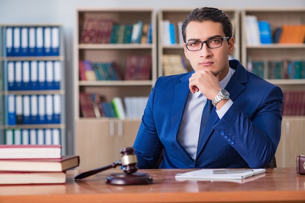 Giudice bello con il martelletto che si siede nell'aula di tribunale