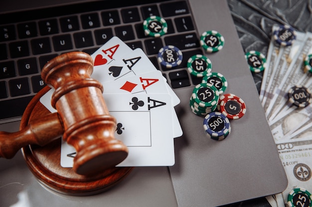 Giudice martelletto di legno, banconote in denaro e carte da gioco sulla tastiera del computer, regole legali per il concetto di gioco d'azzardo online