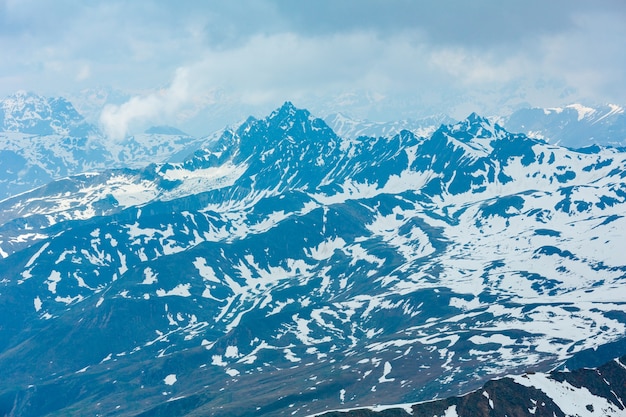 Giugno vista dalla montagna delle Alpi di Karlesjoch (3108 m, vicino a Kaunertal Gletscher sul confine Austria-Italia) oltre il precipizio e le nuvole