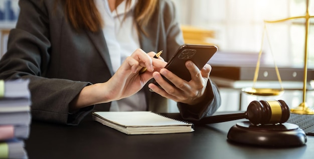 Giustizia e concetto di diritto donna asiatica avvocato che lavora e giudice in un'aula di tribunale il martelletto che lavora con smartphone e laptop e tablet digitale