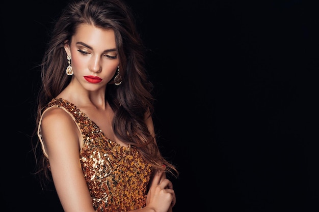 Glamour giovane donna con trucco luminoso con spalle nude in posa nell'ombra