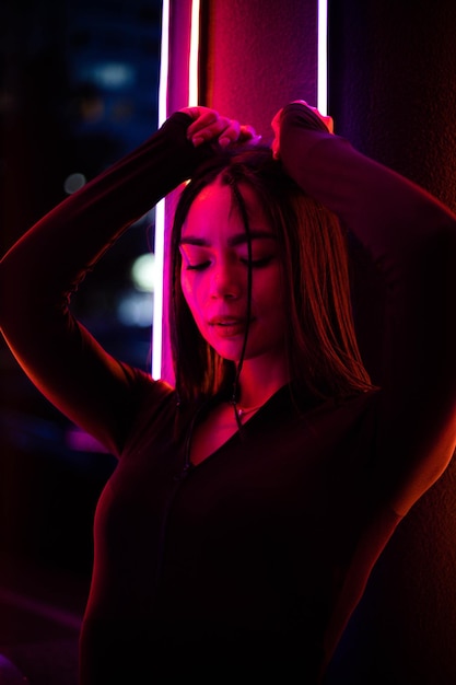 Glamour nell'illuminazione al neon Ritratto di una donna con luci al neon sullo sfondo
