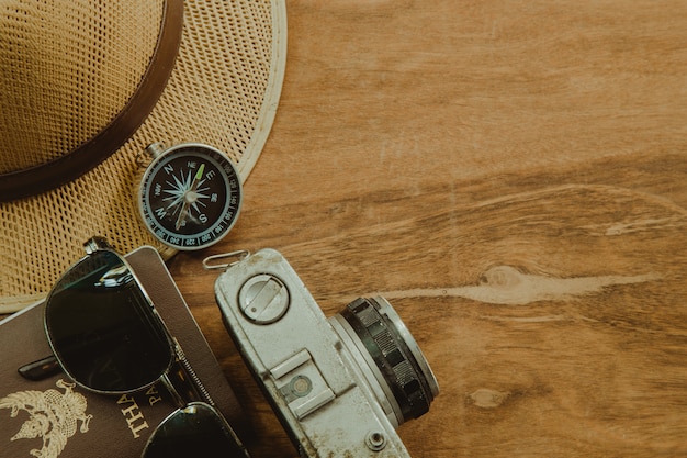 Gli accessori e il costume del viaggiatore su fondo di legno con lo spazio della copia, concetto di viaggio.