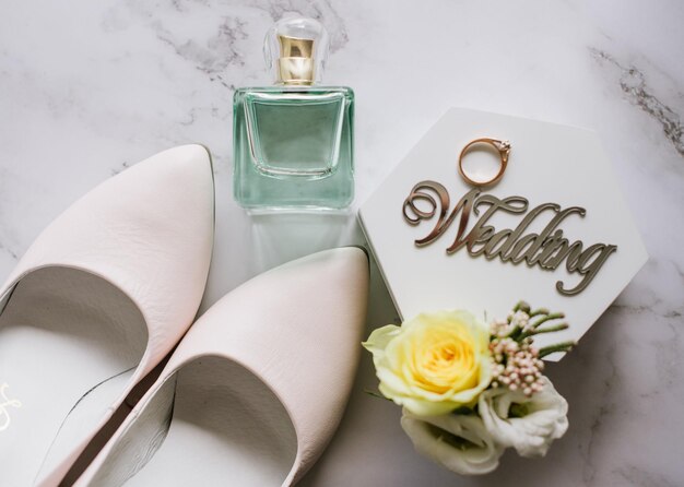 Gli accessori per il matrimonio delle spose fanno l'anello di mazzi di fiori e la carta dell'invito il giorno del matrimonio piatto