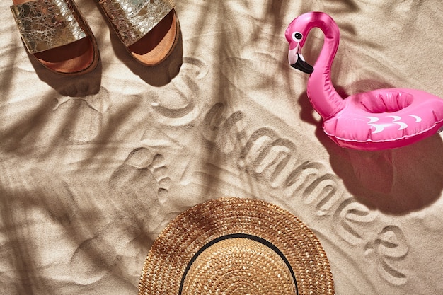 Gli accessori per le vacanze dei viaggiatori sono disposti su una vista piatta dall'alto di una spiaggia di sabbia bianca