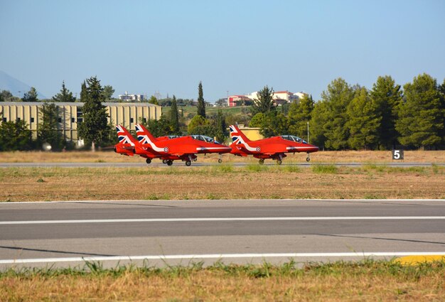 Gli aerei da caccia militari rossi stanno sulla pista in una colonna