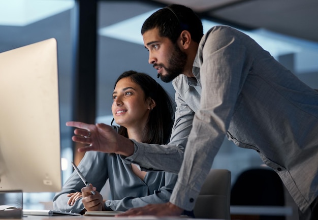 Gli affari vanno avanti quando il personale va d'accordo Inquadratura di un giovane che aiuta il suo collega in un call center a tarda notte