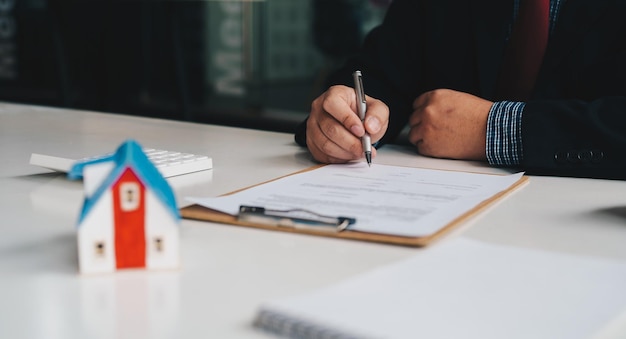 Gli agenti immobiliari firmano la carta del contratto Agente immobiliare broker immobiliare investimento immobiliare acquistare e vendere concetto