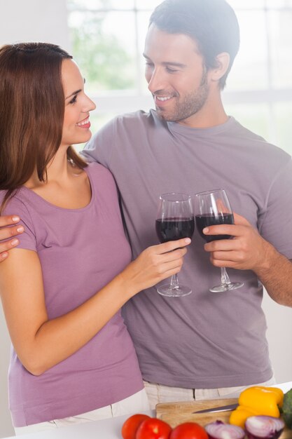 Gli amanti brindando in piedi con un bicchiere di vino