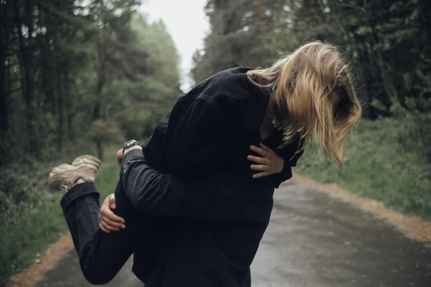 Gli amanti si abbracciano nella foresta in caso di pioggia
