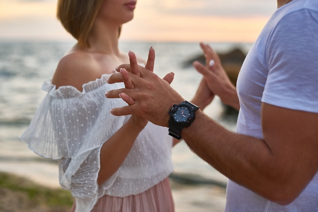 Gli amanti uomo e donna abbracciano e baciano in piedi sulla scogliera